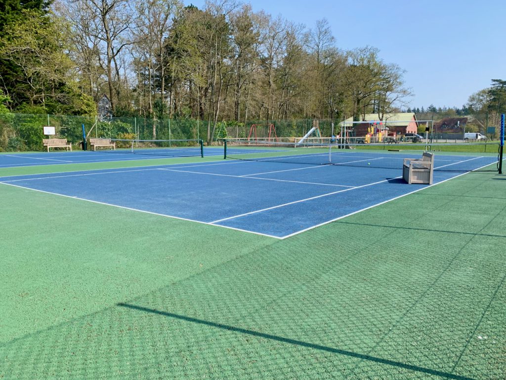The Cold Ash Tennis Courts are blue with a green tarmac surround.
