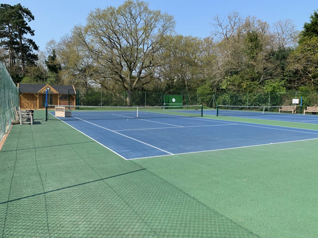 The Cold Ash Tennis Courts are blue with a green tarmac surround.